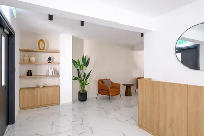 a living room with a chair and a mirror at Artemis 105 - Seaside Stories in Livadhia