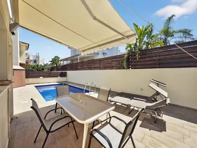 a patio with a table and chairs and a pool at Villa Rena - 3BR Retreat near Kalamies Beach in Paralimni