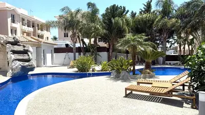 a swimming pool with two benches and palm trees at Majestic Sea View Apartment in Tersephanou