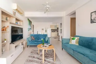 a living room with two blue couches and a table at Majestic Sea View Apartment in Tersephanou