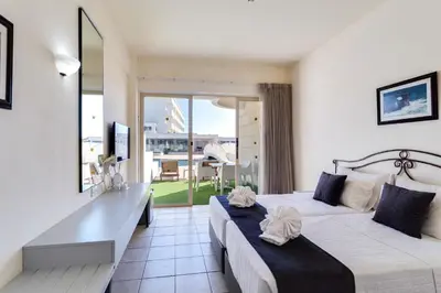 a hotel room with two beds and a desk at Piere - Anne Beach Hotel in Ayia Napa