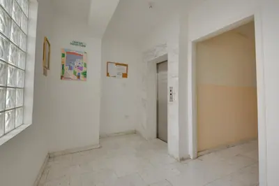 a hallway with a white wall and a door at Penthouse Central Larnaca The 'Veranda' Elena Court in Larnaka