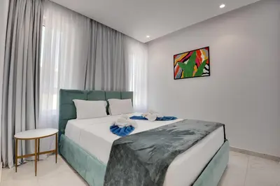 a hotel room with a bed and a chair at Oniro Suites Makenzy in Larnaka