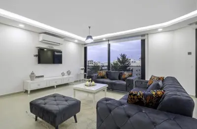 a living room with two couches and a tv at Avrasya city in Ayios Dhometios