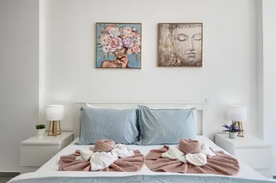 a bedroom with a bed with towels on it at Carisa Elysium Larnaca in Larnaka