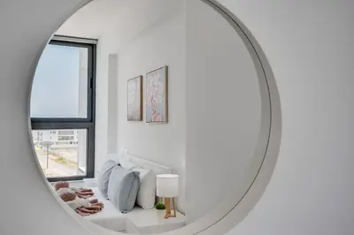 a white room with a white couch and a mirror at Carisa Elysium Larnaca in Larnaka