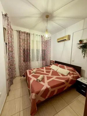 a bedroom with a bed and curtains and a chandelier at Alison rooms in center in Larnaka