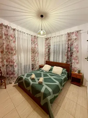 a bedroom with a bed and curtains and a chandelier at Alison rooms in center in Larnaka