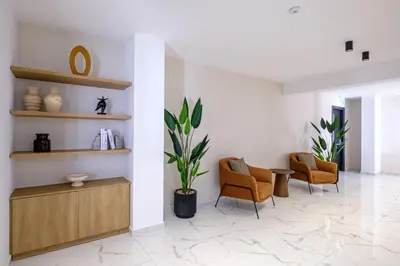 a lobby with chairs and a table and a plant at Artemis 104 - Seaside Stories in Livadhia