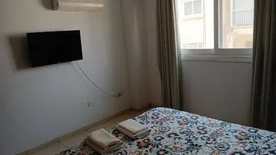 a bedroom with a bed with a tv on the wall at Unique City room in Larnaka