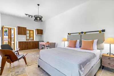 a bedroom with a large bed and a kitchen at Kallistheni - Stylish Studio Apartments in Lefkara in Pano Lefkara