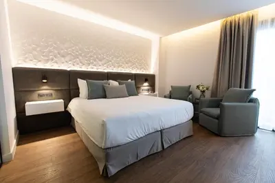 a bedroom with a large bed and two chairs at Old Port Hotel in Limassol