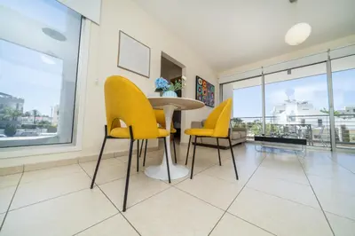 a dining room with yellow chairs and a table at Modern 1 bedroom flat in Strovolos