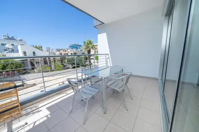 a glass table and chairs on a balcony with a view at Modern 1 bedroom flat in Strovolos