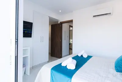 a white bedroom with a blue and white bed at Dahlia Napa Villa in Ayia Napa
