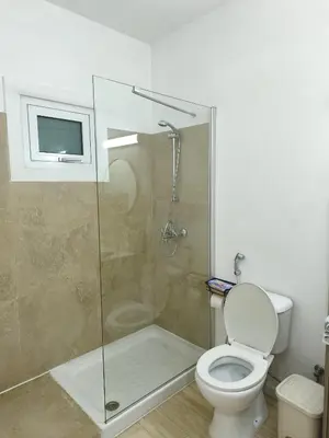 a bathroom with a shower and a toilet and a television at Domus ArsEleAndra Studio-162 in Larnaka