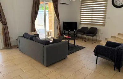 a living room with a couch and a table at Villa Rossa in Pissouri