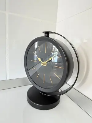 a black clock sitting on top of a table at Yenikent's Diamond in Nicosia
