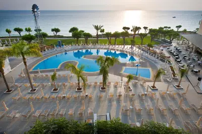 an overhead view of a pool with chairs and the ocean at Pernera Beach Hotel in Protaras