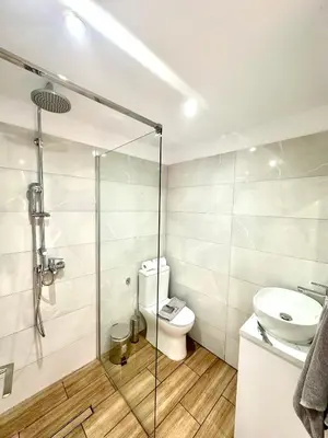 a bathroom with a toilet and a glass shower at SeaBastian Suite in Ayia Napa