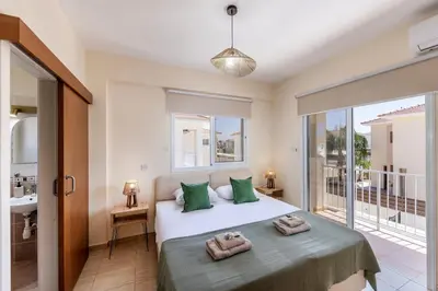 a bedroom with a bed with two towels on it at Villa Chrystalla in Paralimni