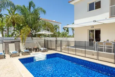 a swimming pool in the backyard of a house at Villa Chrystalla in Paralimni