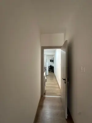 an empty hallway with an open door to a room at Finikoudes Central Apartment in Larnaka