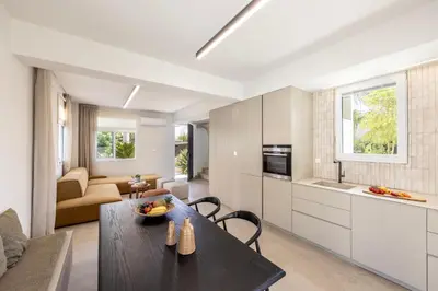 a kitchen and living room with a table and a couch at Villa Mesogeios 4 in Protaras