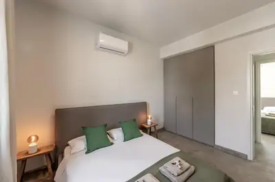 a bedroom with a large white bed with green pillows at Villa Mesogeios 4 in Protaras