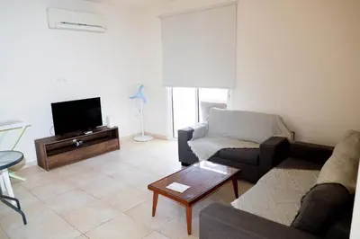 a living room with a couch and a tv at Agesilaos Seaview 33 in Ayia Napa