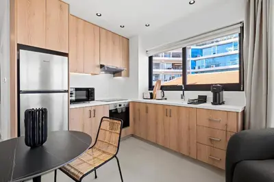 a kitchen with a table and a refrigerator at Finikoudes Marina View #201 in Larnaka