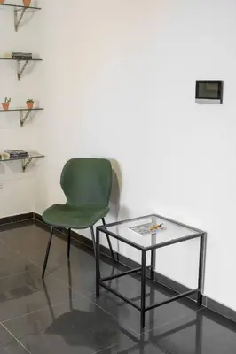 a green chair sitting next to a glass table at Central 2 bdr Flat St Lazaros - Phoenix Lodge in Larnaka