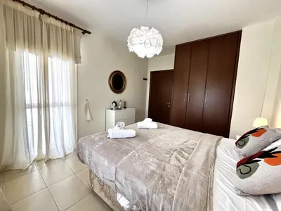 a bedroom with a large bed and a chandelier at STAY Sunny Palms Penthouse in Voroklini