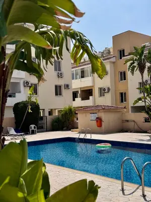 a swimming pool in front of a building at STAY Sunny Palms Penthouse in Voroklini