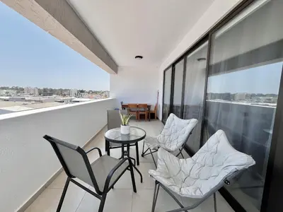 a balcony with chairs and a table on a building at STAY Sealine Apartment in Larnaka