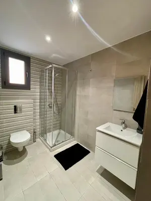 a bathroom with a shower and a toilet and a sink at Modern Designer Home in Larnaka