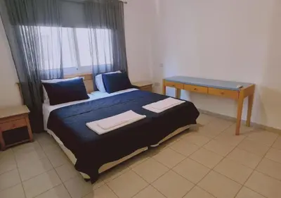 a bedroom with a bed with a desk and a window at Nissi Cove 2 Bedroom Apartment in Ayia Napa
