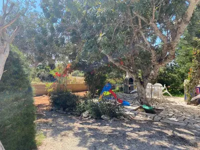 a playground in a yard with a tree at Konnos Villa in Protaras
