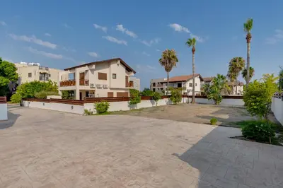 a villa with a large driveway and palm trees at Amelia Beach Villa wpool -500mfrombeach in Voroklini