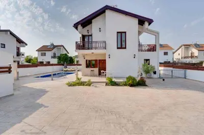 a large white house with a large courtyard at Amelia Beach Villa wpool -500mfrombeach in Voroklini
