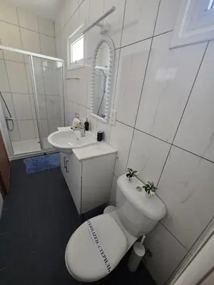 a white bathroom with a toilet and a sink at Lazuli Penthouse City Center Ap 5 in Larnaka