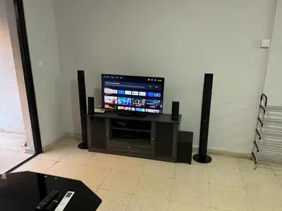 a flat screen tv sitting on a stand with speakers at The relaxing apartment in Paralimni
