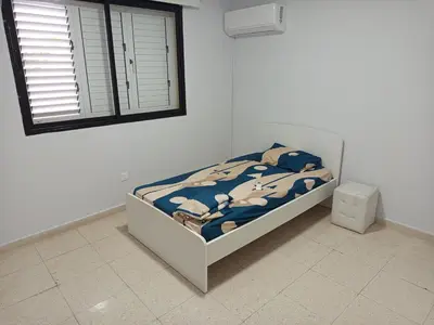 a bedroom with a bed with a comforter and a window at The relaxing apartment in Paralimni