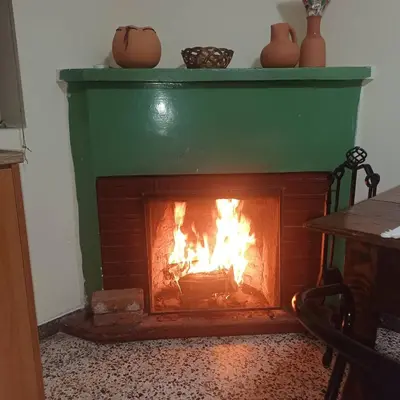 a brick fireplace with a fire in it at Casa del Kampos in Kambos