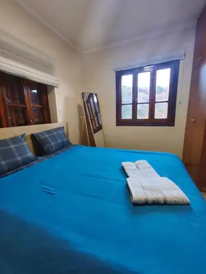 a bedroom with a blue bed with two towels on it at Casa del Kampos in Kambos