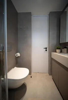 a bathroom with a white toilet and a door at Dest Retreat Beach & City Apt in Limassol