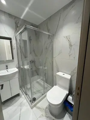 a bathroom with a shower and a toilet and a sink at Larnaca Elysium Seaside & Pool Retreat in Livadhia