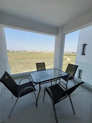 a table and chairs in a room with a window at Larnaca Elysium Seaside & Pool Retreat in Livadhia