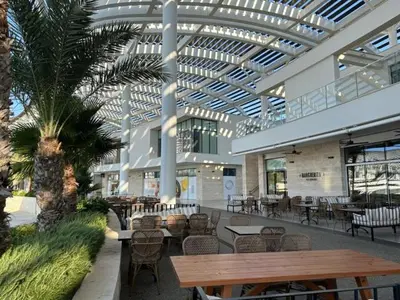 a building with a cafeteria with tables and chairs at Ayia-Napa Marina Luxury Appartments in Ayia Napa