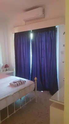 a bedroom with a bed with a blue curtain at Nice Room in Limassol center in Limassol